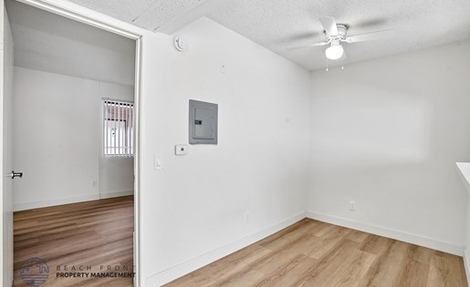 A room with a white wall and a wooden floor.